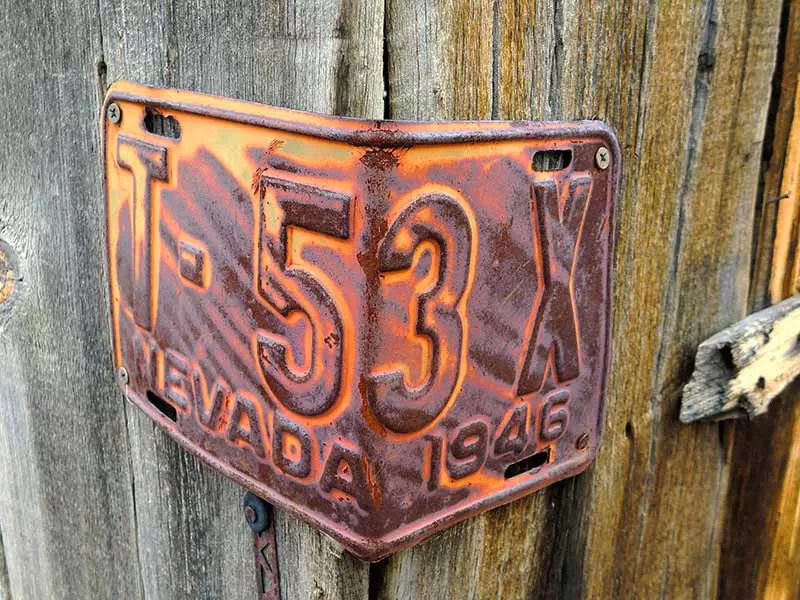 Authorized Smog Busters representative delivering replacement Nevada license plates to a customer after handling the DMV visit on their behalf